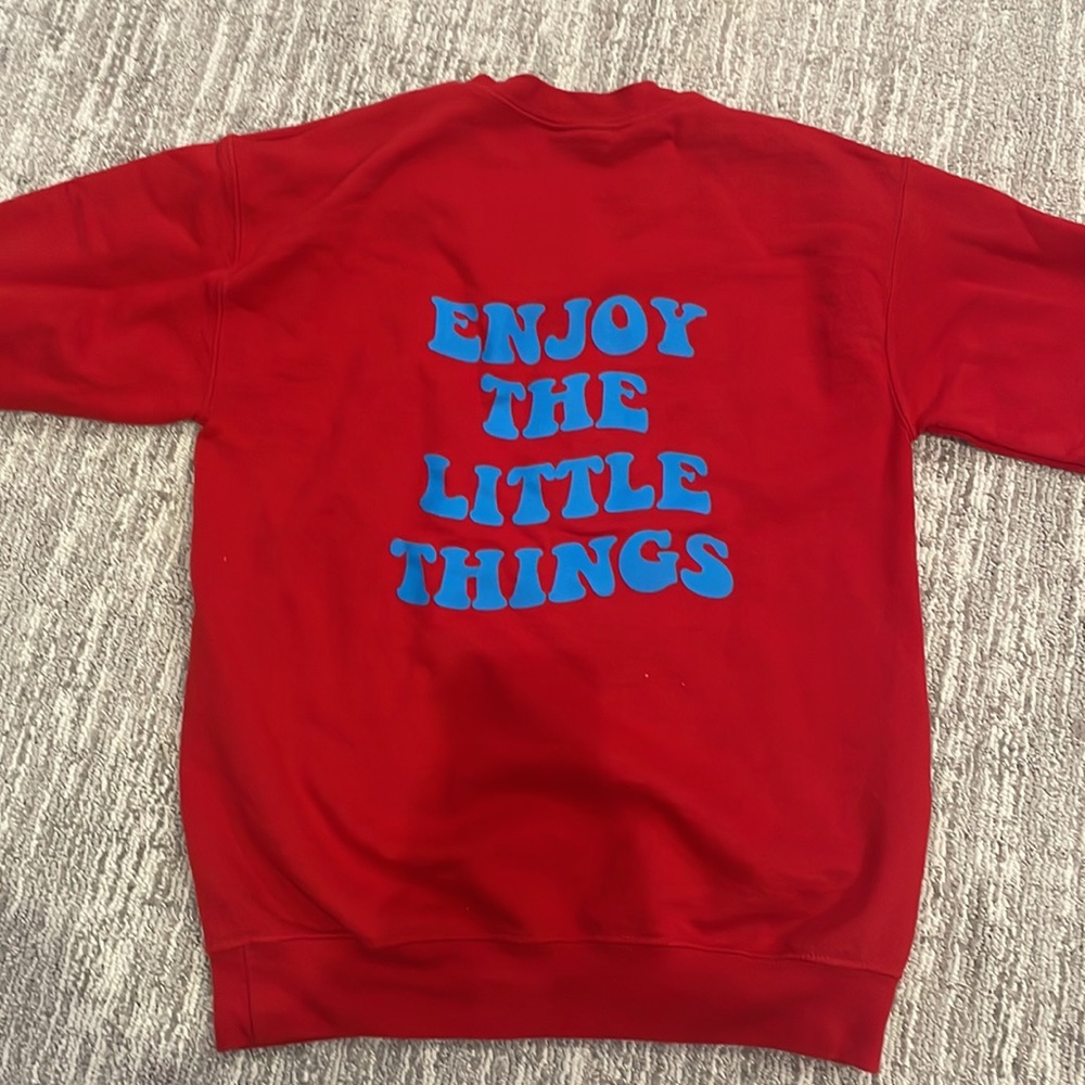 red crewneck w/ “enjoy the little things” message on back
